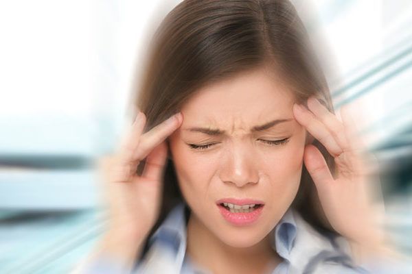 A woman is holding her head because she has a headache.