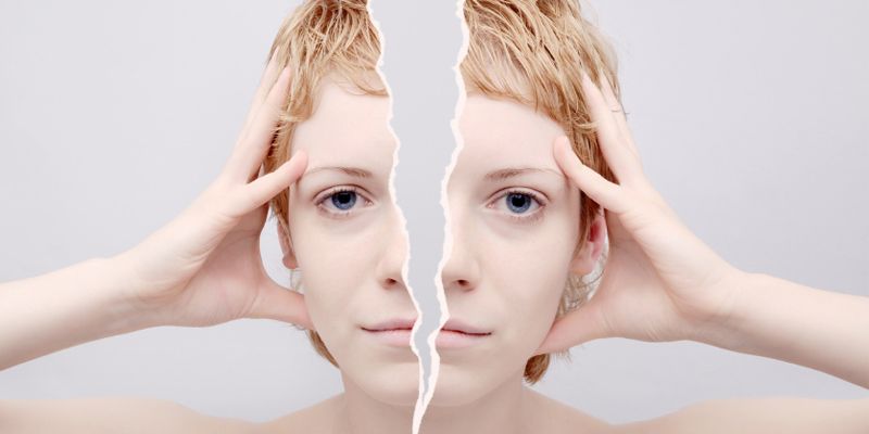 A woman 's face is split in half by a piece of paper.