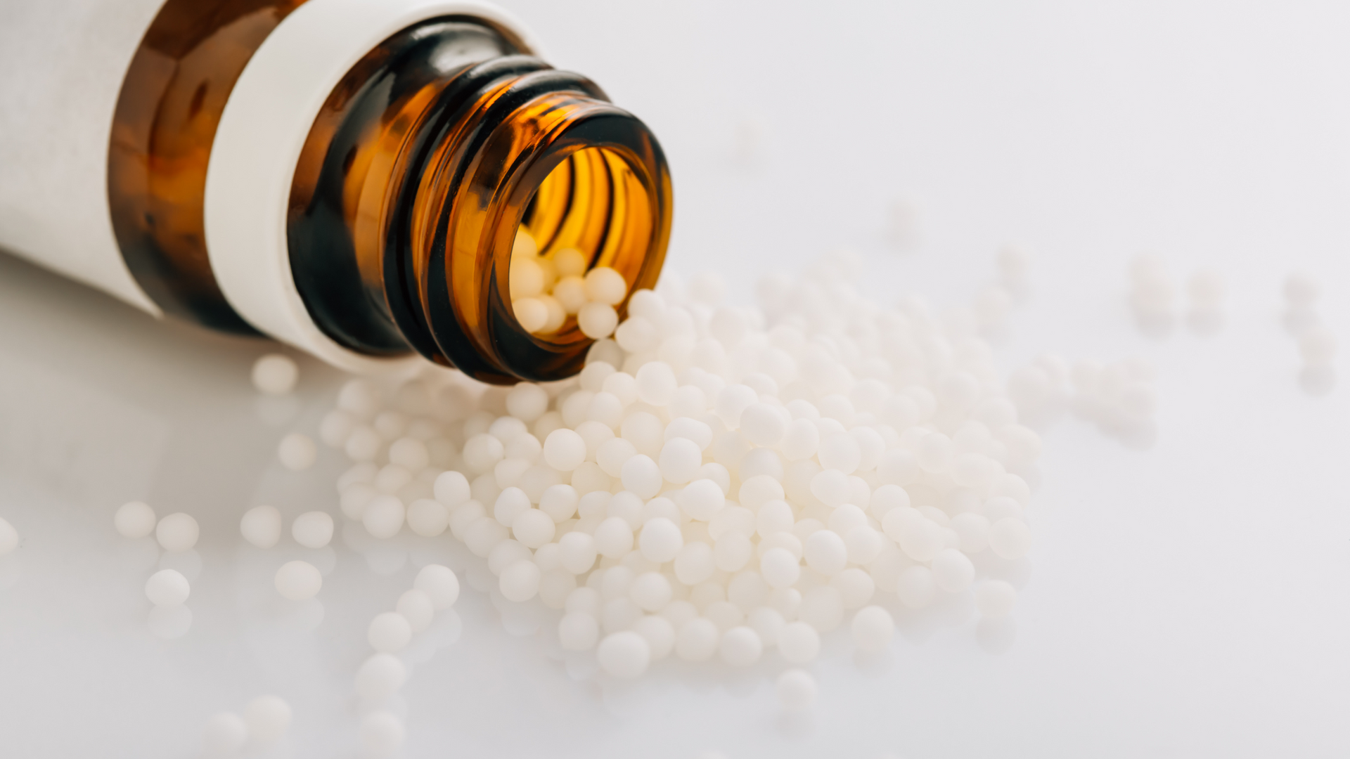 A bottle of homeopathy pills is pouring out of it.
