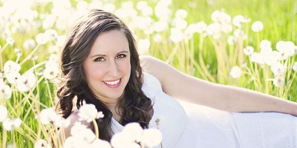 A woman in a white dress is laying in a field of white flowers.