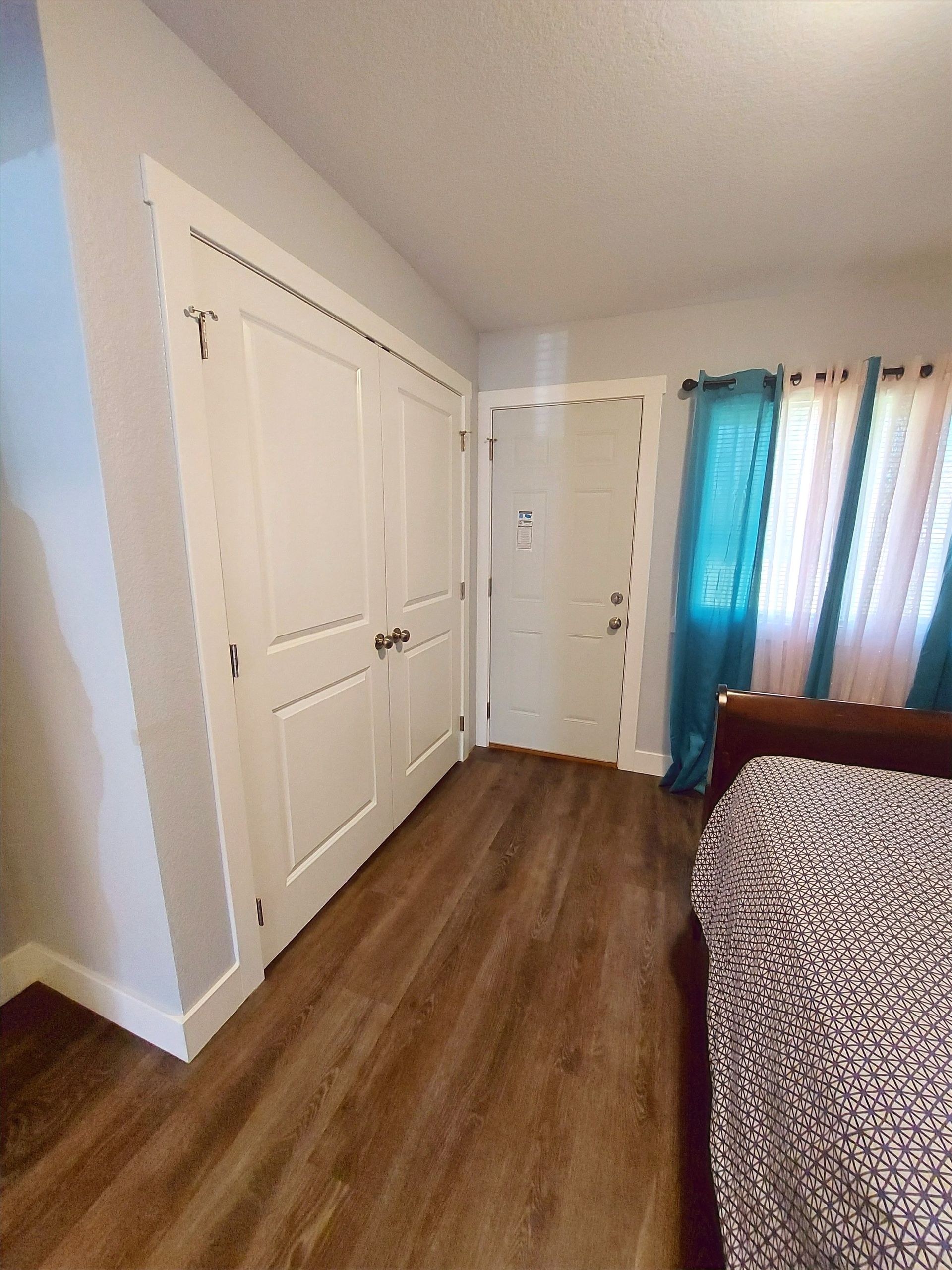 A bedroom with a bed , closet , and door.