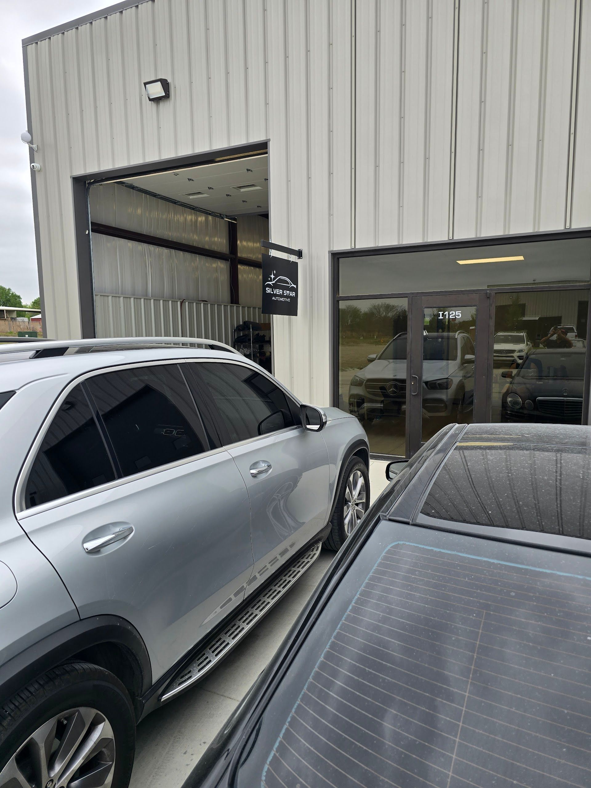 Silver Mercedes-Benz Parked Outside Silver Star Automotive Shop Entrance | Silver Star Automotive