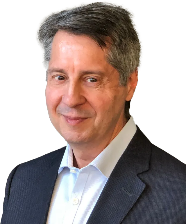 Man in navy blazer and light blue shirt, smiling at camera.