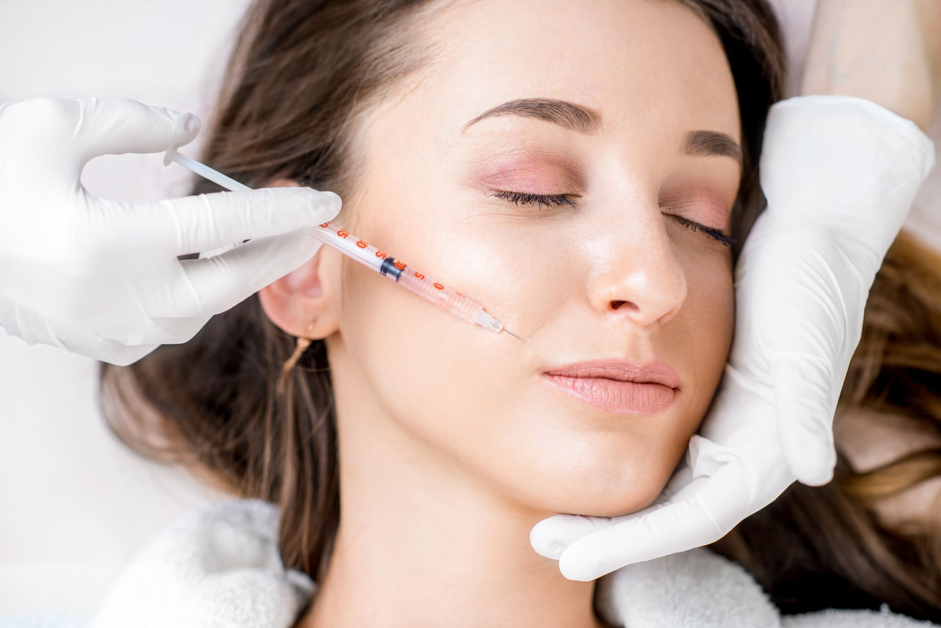 A woman is getting Botox injected in the lip zone. A woman is getting Botox injected in the lip zone.