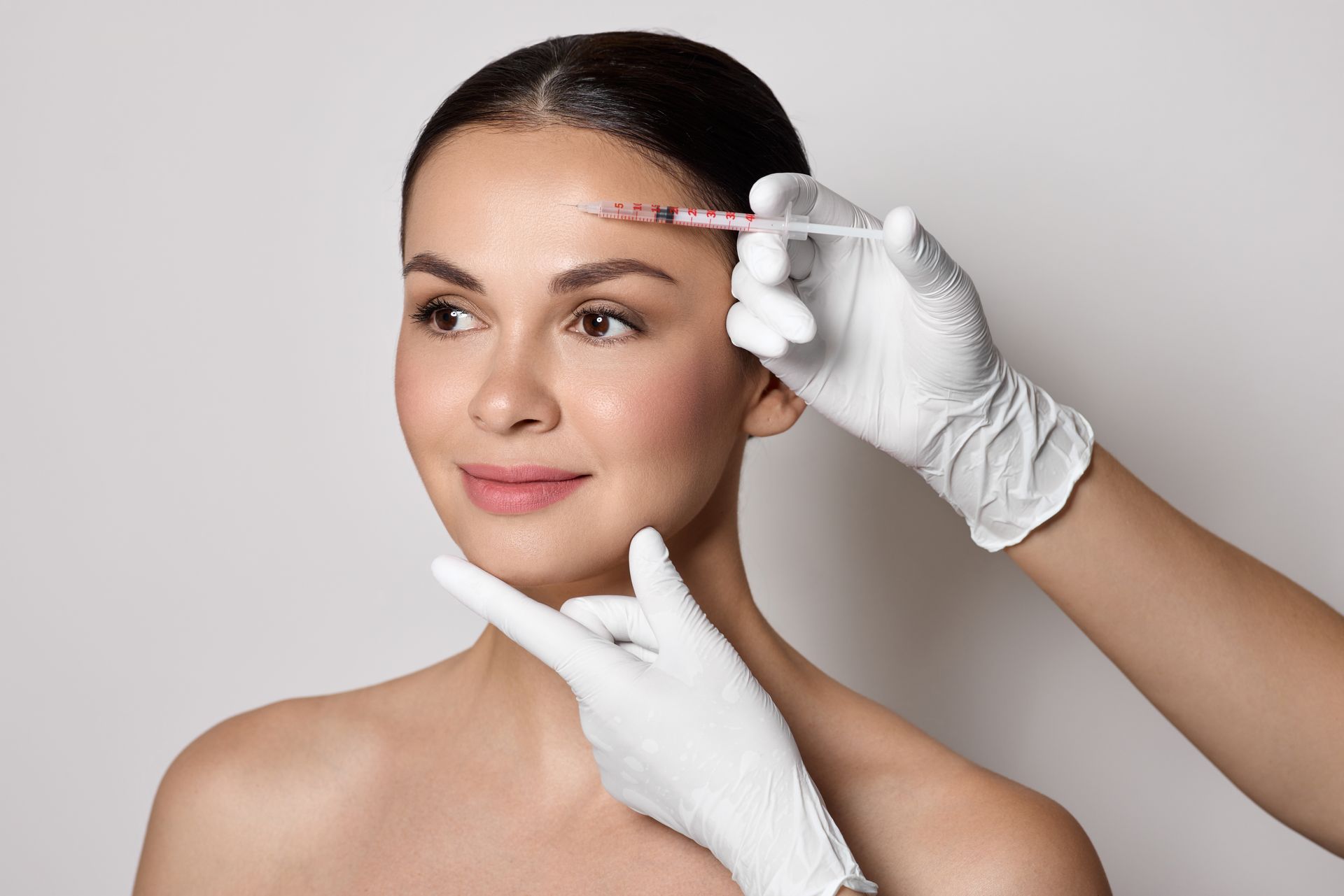 Botulinum toxin injections near a woman's forehead for blocking mimic wrinkles and wrinkles removal. Botulinum toxin injections near a woman's forehead for blocking mimic wrinkles and wrinkles removal.