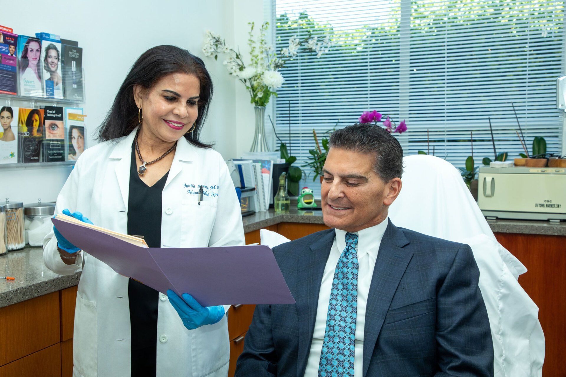 Doctor showing a patient a file in a medical office. Both are smiling.