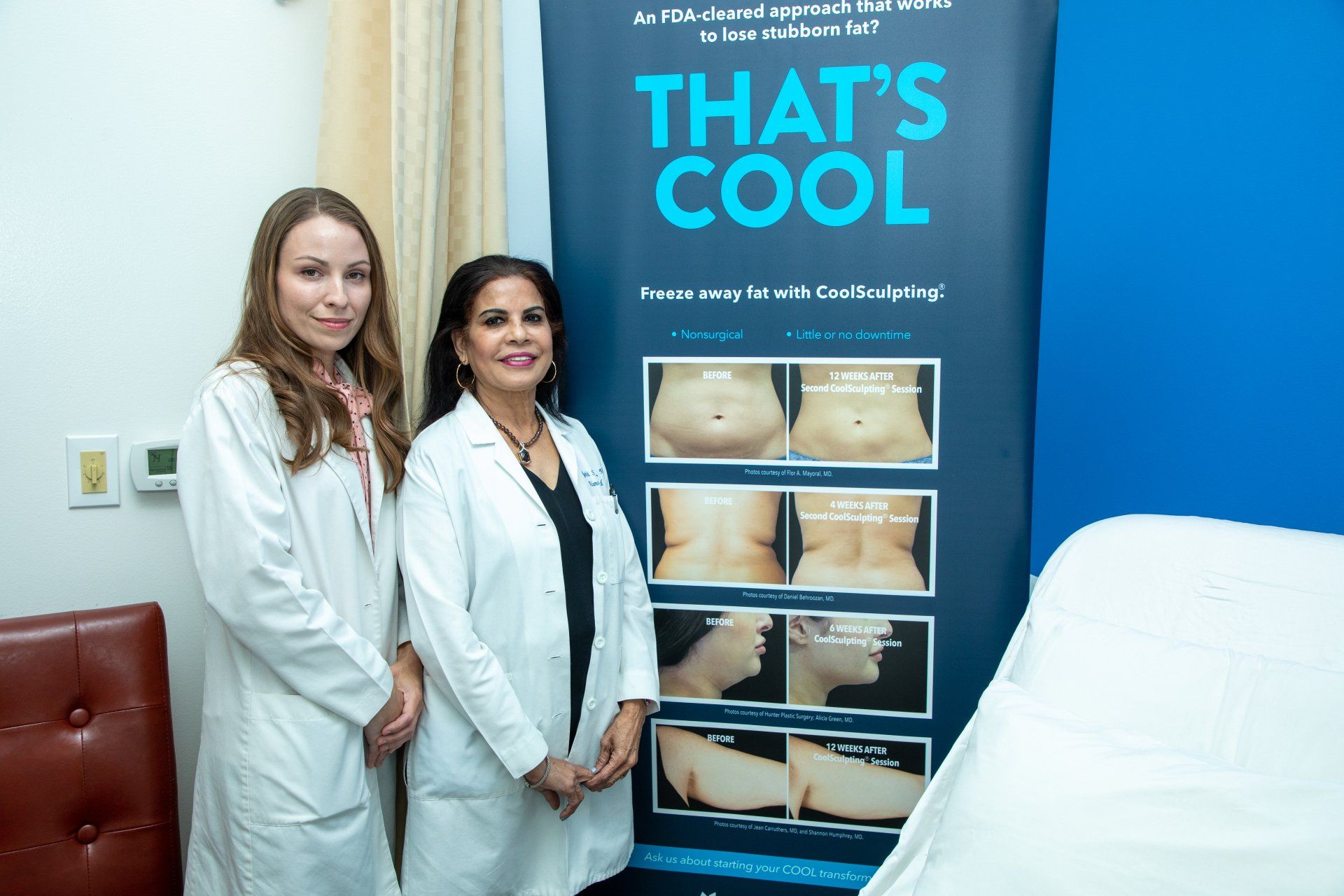 Two medical professionals stand beside a 