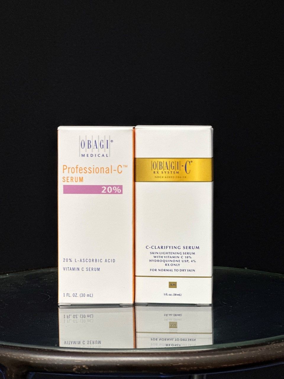 Two white Obagi skincare product boxes on a reflective surface against a black background.
