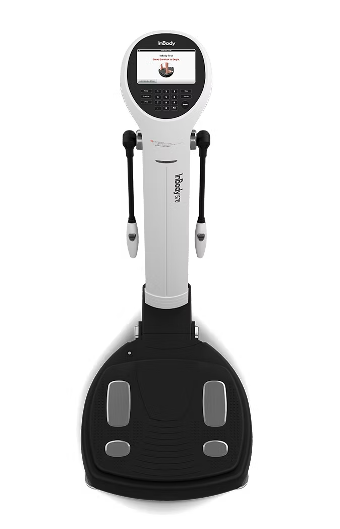 A white and black body composition analyzer with a display screen and handles.