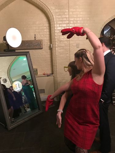 A woman in a red dress is posing in front of a mirror me Photo Booth 