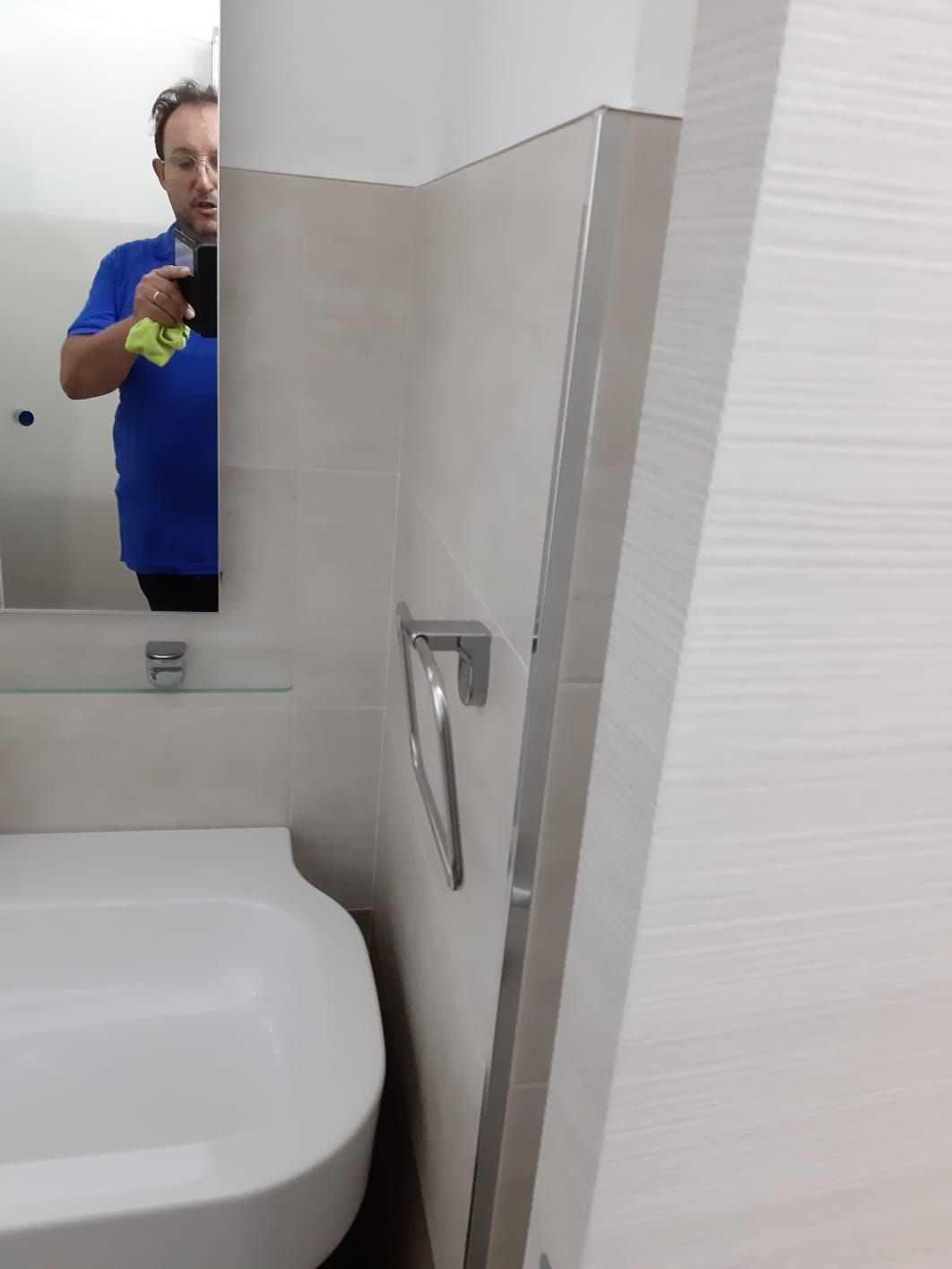 Un uomo che si scatta una foto allo specchio del bagno
