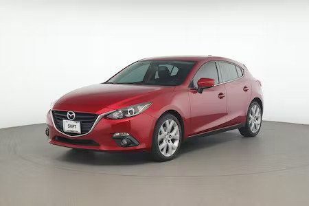 Red Mazda sedan on a studio backdrop, front-left view.