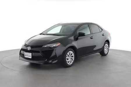 Black sedan car in a studio, angled front-left view on a white background