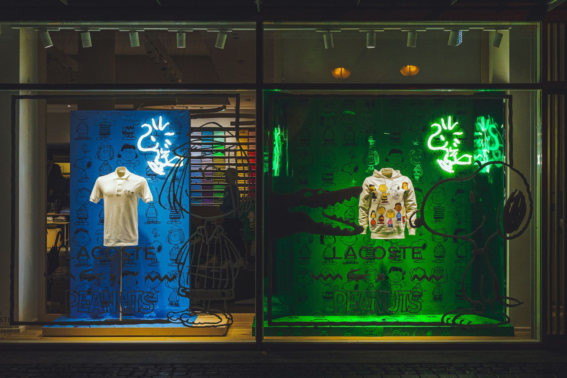 Two Lacoste store window displays featuring polo shirts, with blue and green neon Snoopy outlines and backgrounds.