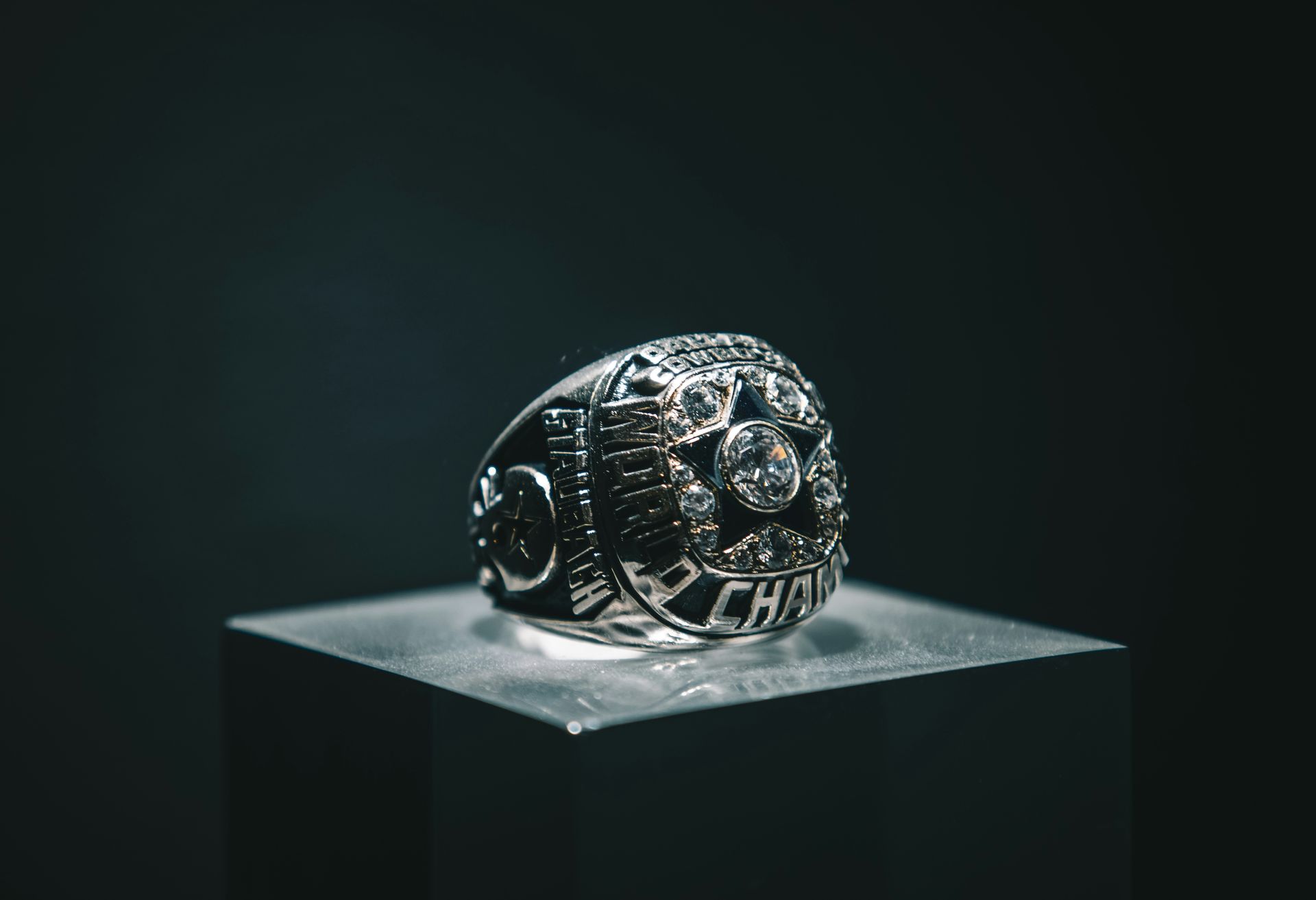 A silver ring is sitting on top of a glass block.