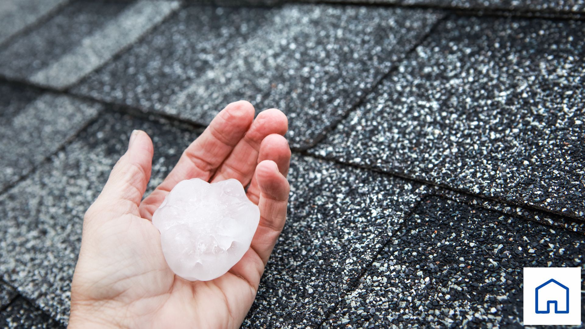 A person is holding a piece of hail in their hand.