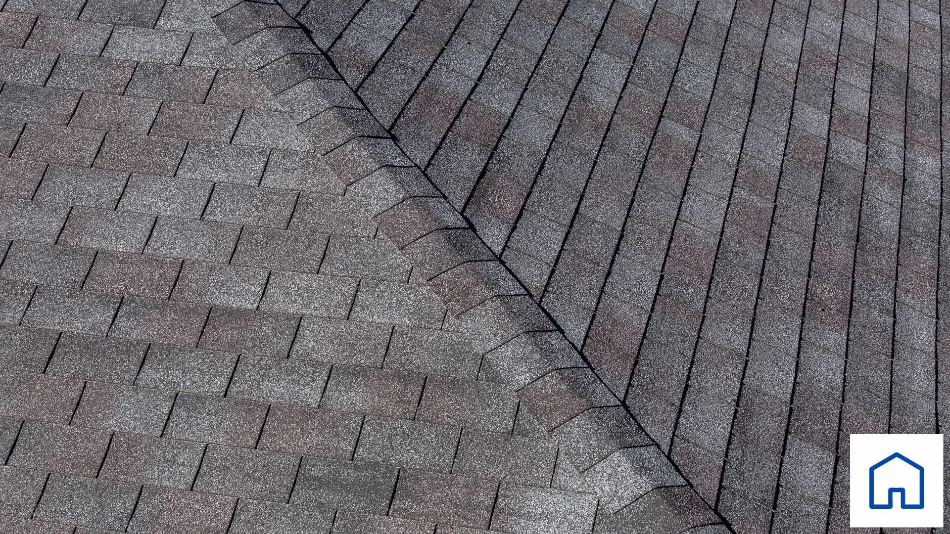 A close up of a roof with a house in the background.