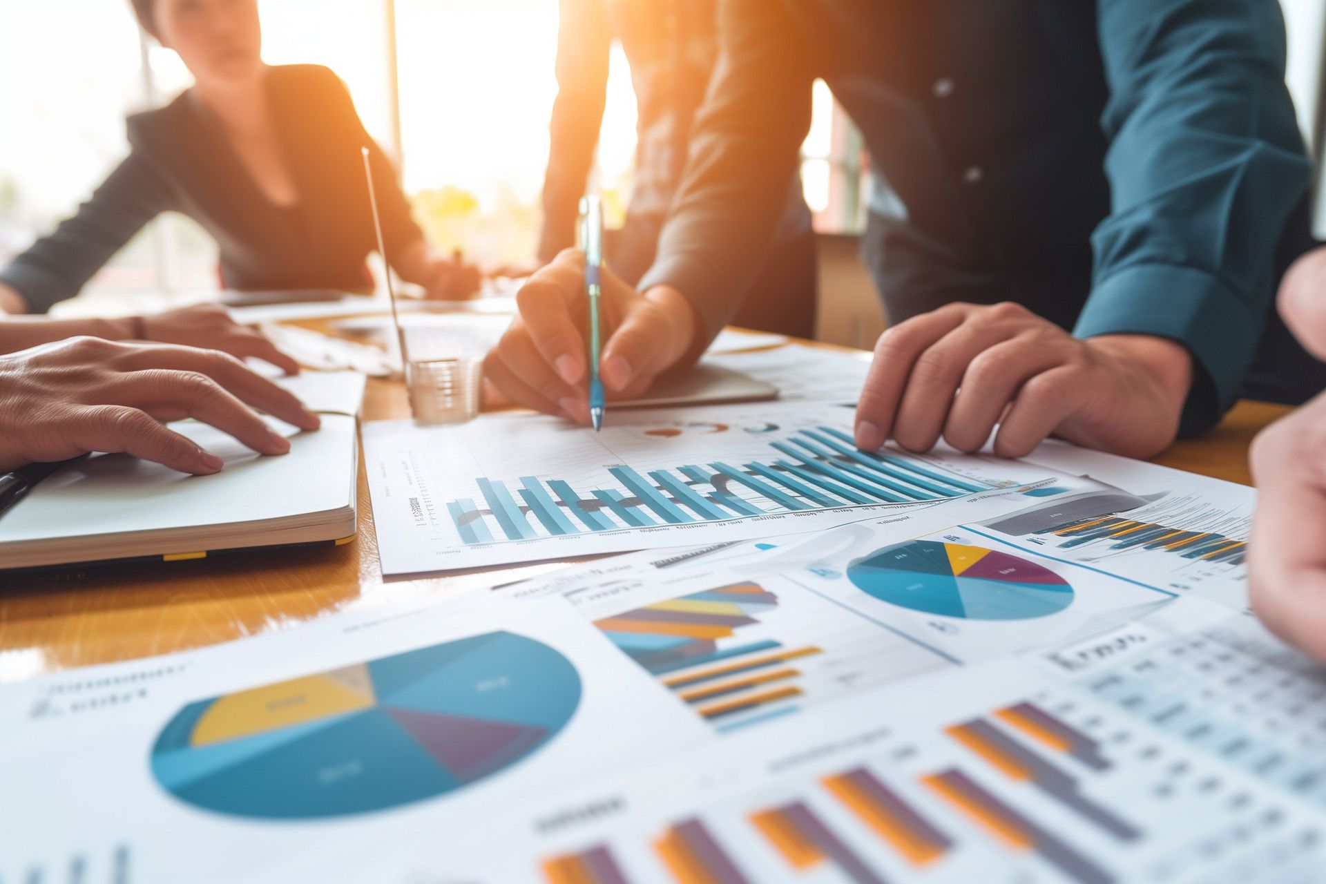 A group of people are sitting around a table looking at charts and graphs.