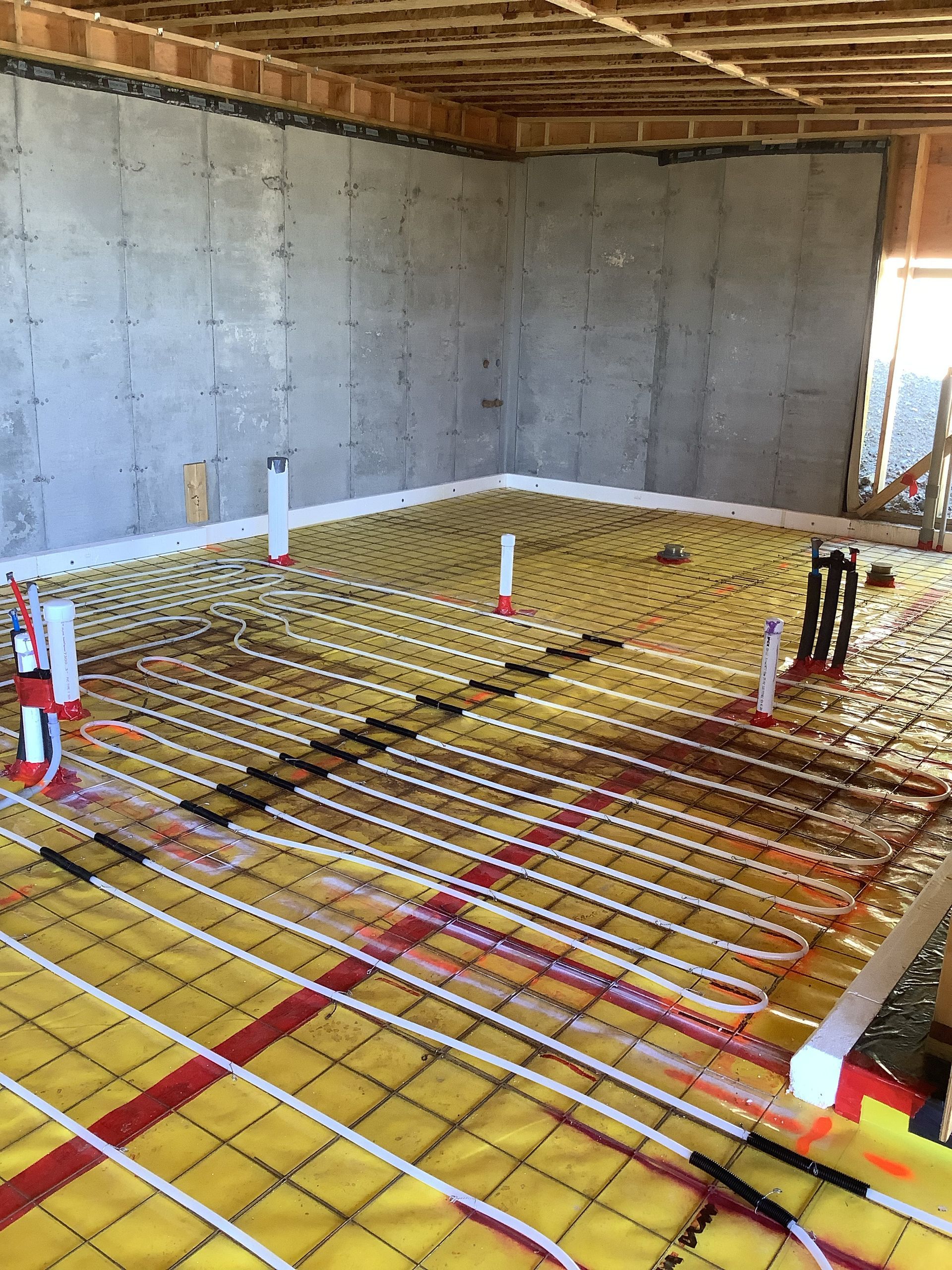 Interior construction site with concrete walls and floor rebar grid for a slab pour