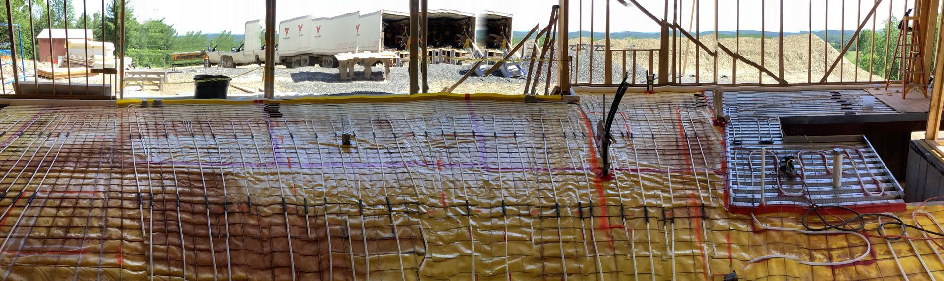 Rusty rebar grid at a construction site with workers and equipment in the background
