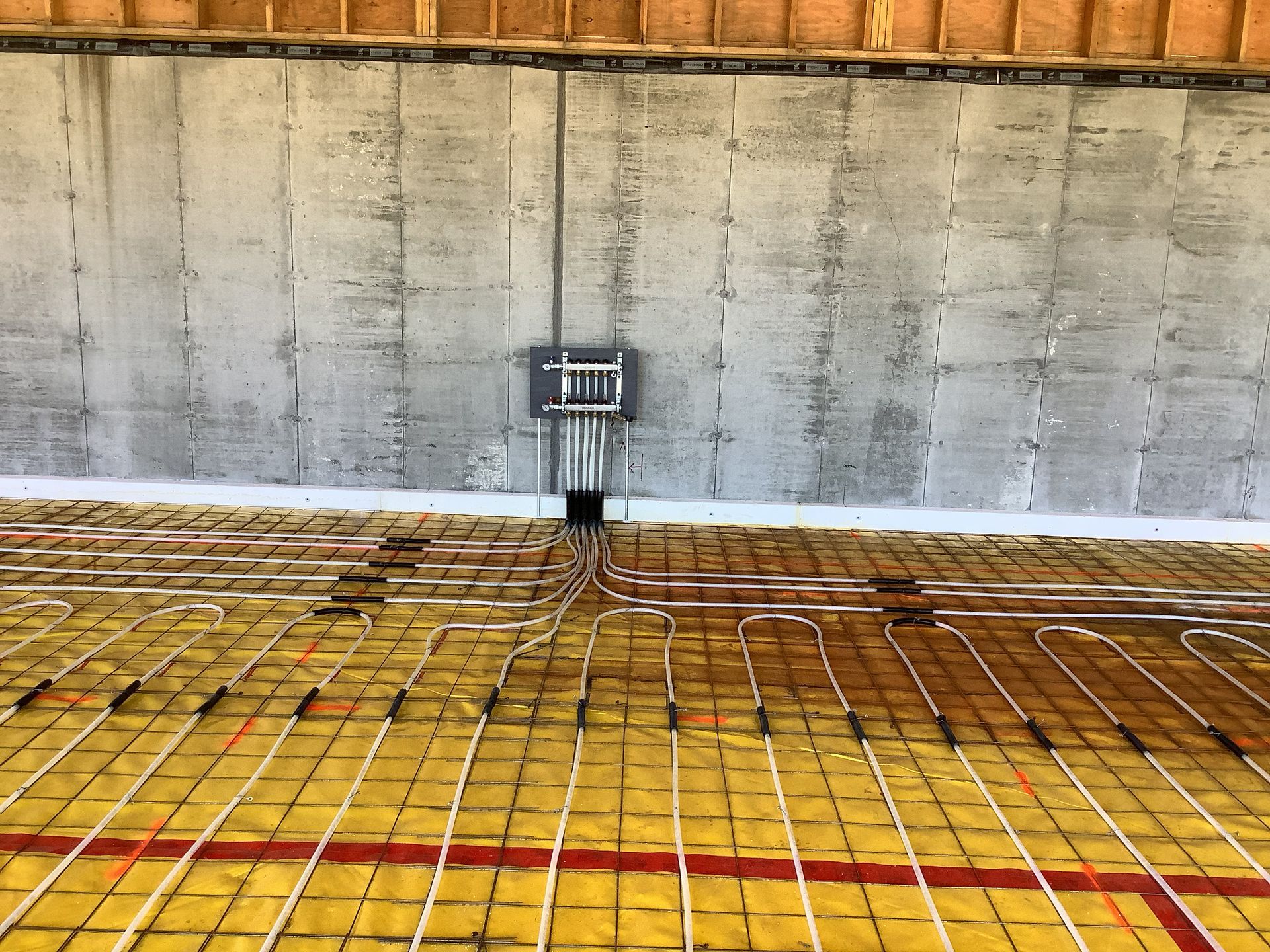 Construction site with concrete wall, rebar grid floor, and a small electrical box mounted at center