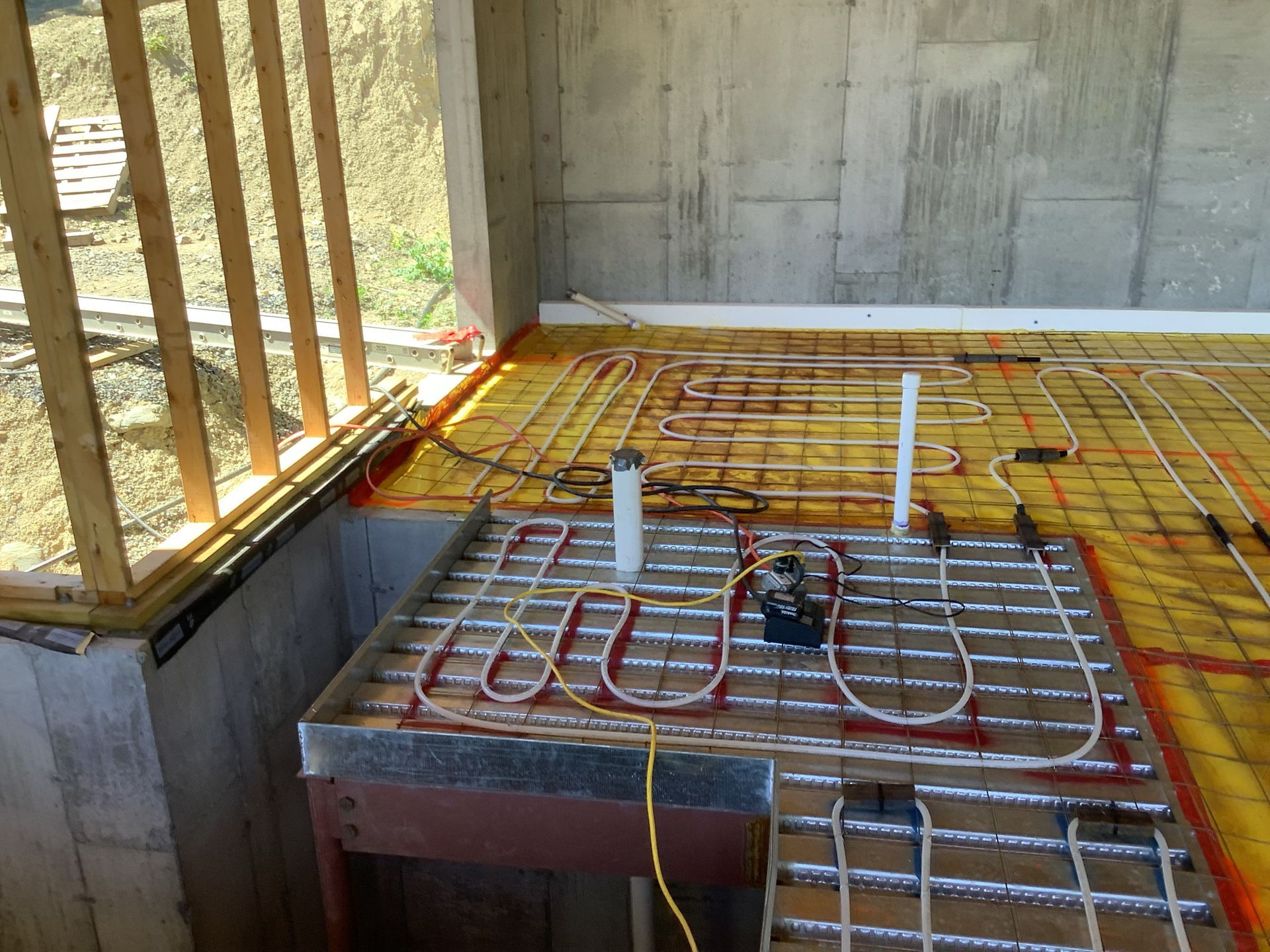 Floor heating pipes laid on rebar in a concrete room under construction