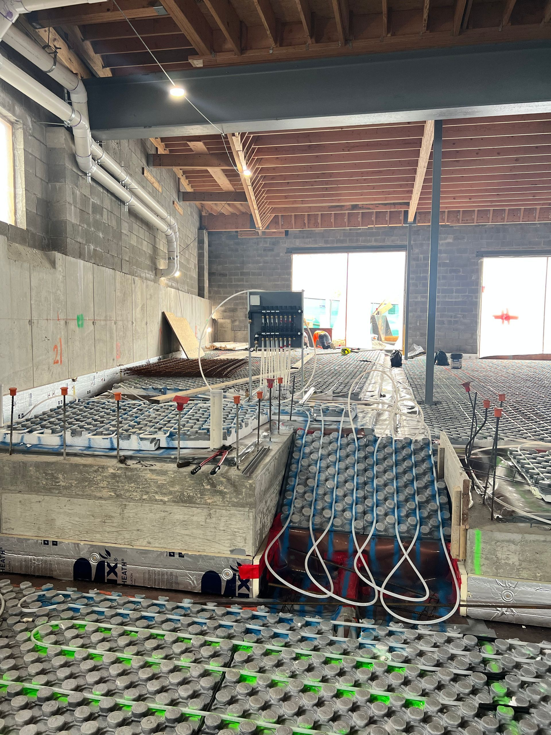 Rows of batteries and wires in a warehouse-like workshop with bright daylight at the far end