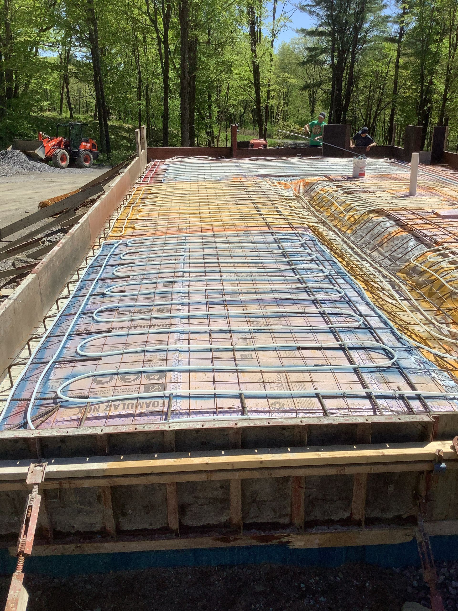 Construction site with rebar and concrete forms for a foundation in a wooded area
