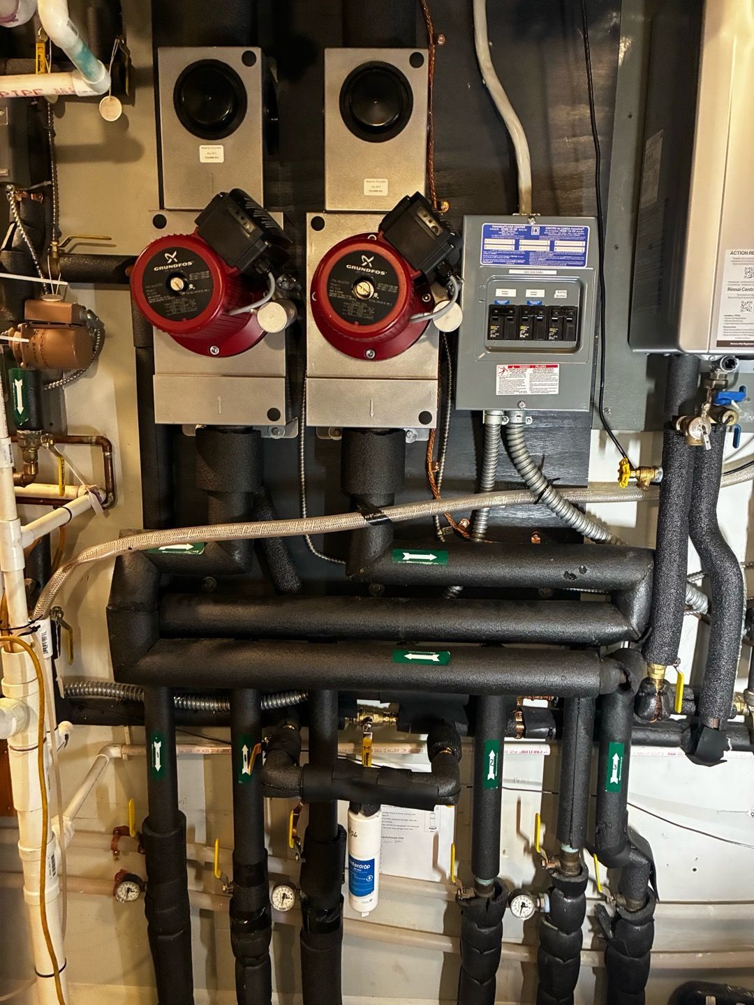 Mechanical HVAC equipment with red circular fans, black pipes, and a control panel in a utility room