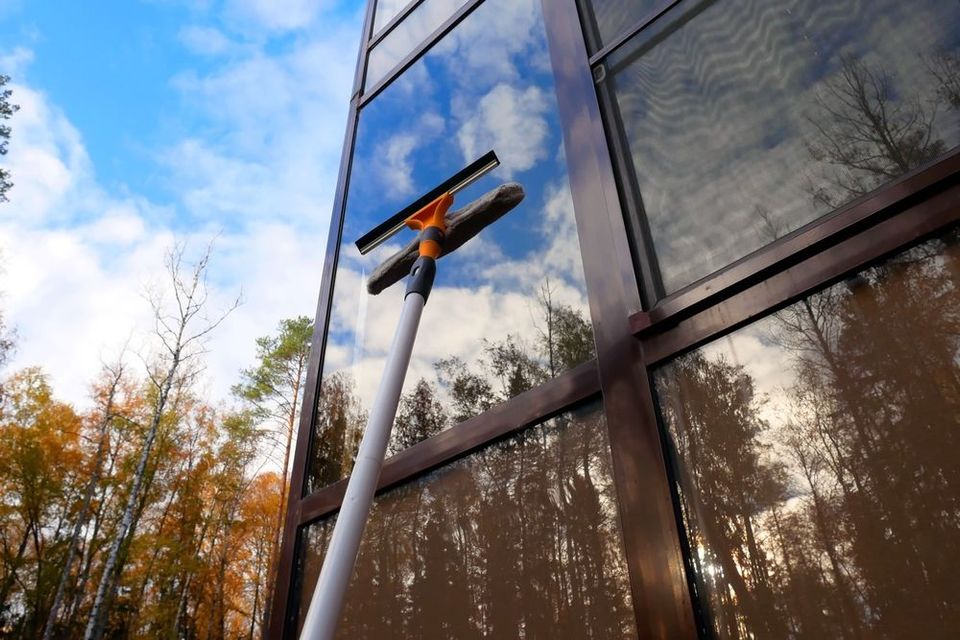 A person is cleaning a window with a squeegee.