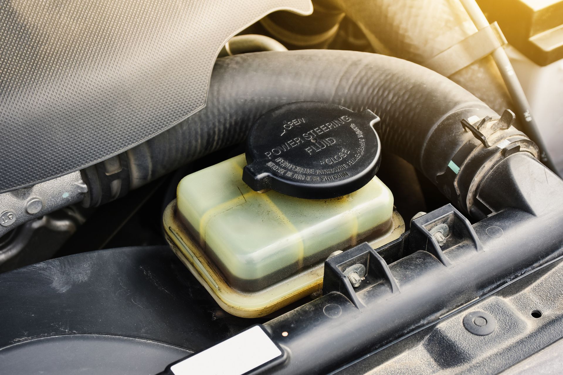 A close up of a brake fluid reservoir in a car engine.