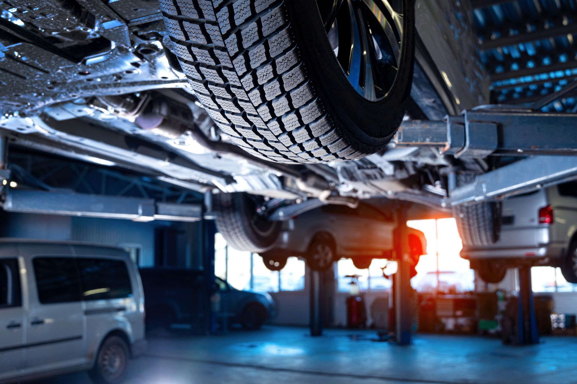 A car is sitting on a lift in a garage.