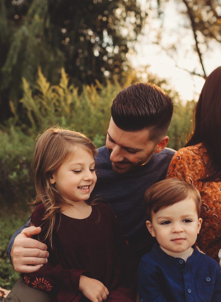A man and a woman are sitting next to each other with two children.
