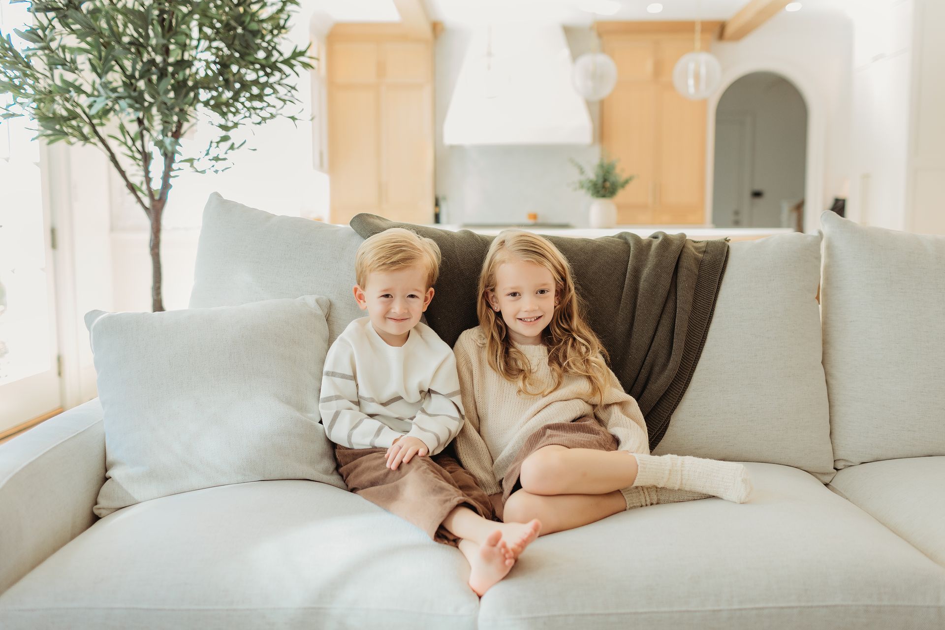 A boy and a girl are sitting on a couch.
