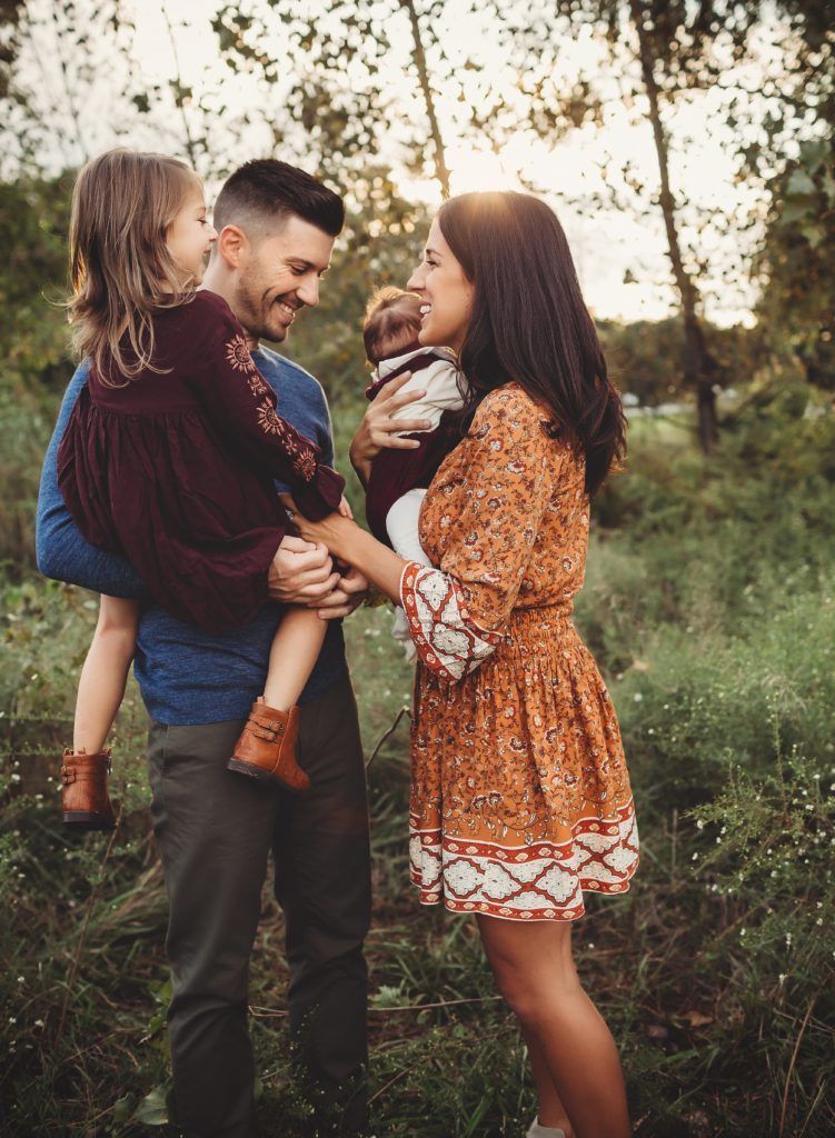A family is posing for a picture in a field.