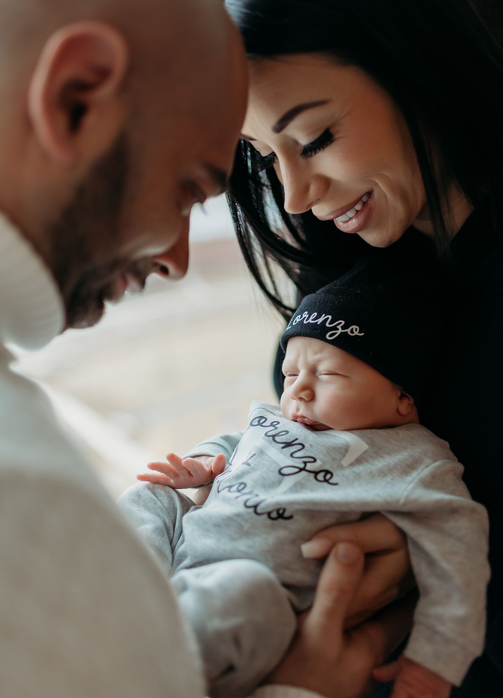 A man and woman are holding a baby in their arms.
