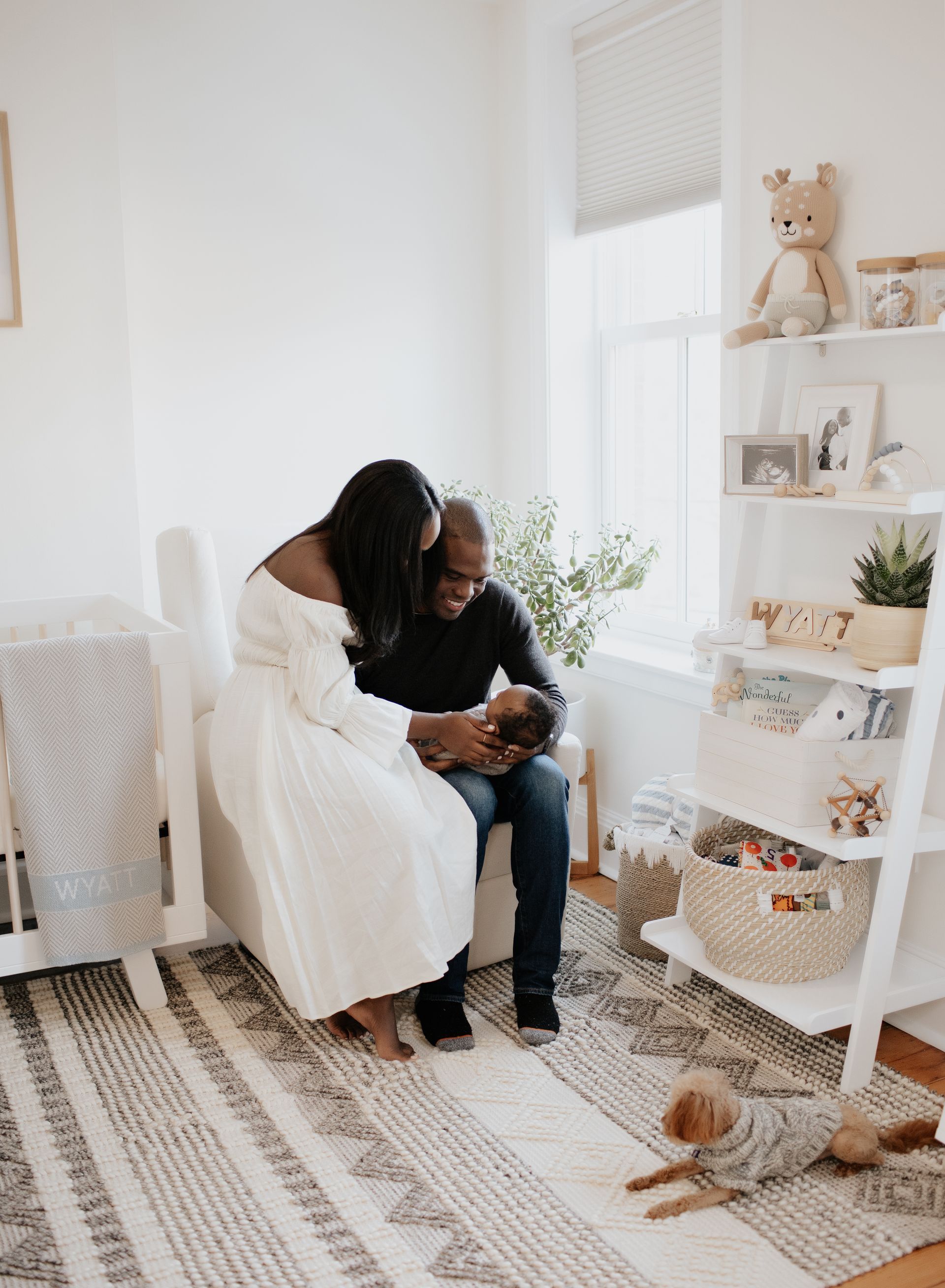 A man and woman are holding a baby in a nursery.