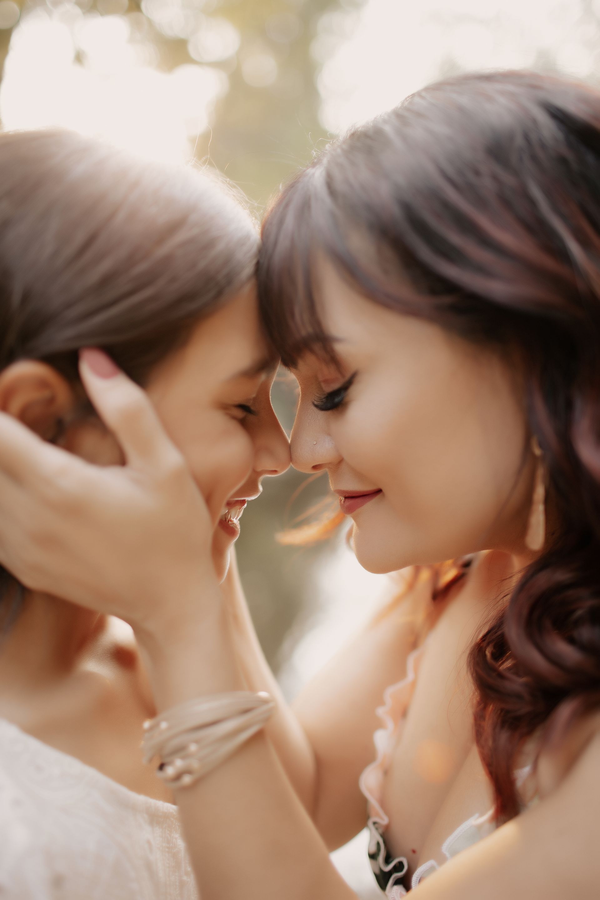 Family of five smiles on a boardwalk, Ferris wheel in background. Woman hugs a girl and holds a boy.