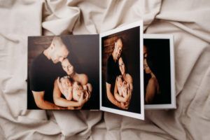 A man and woman are holding a baby in a photo album.