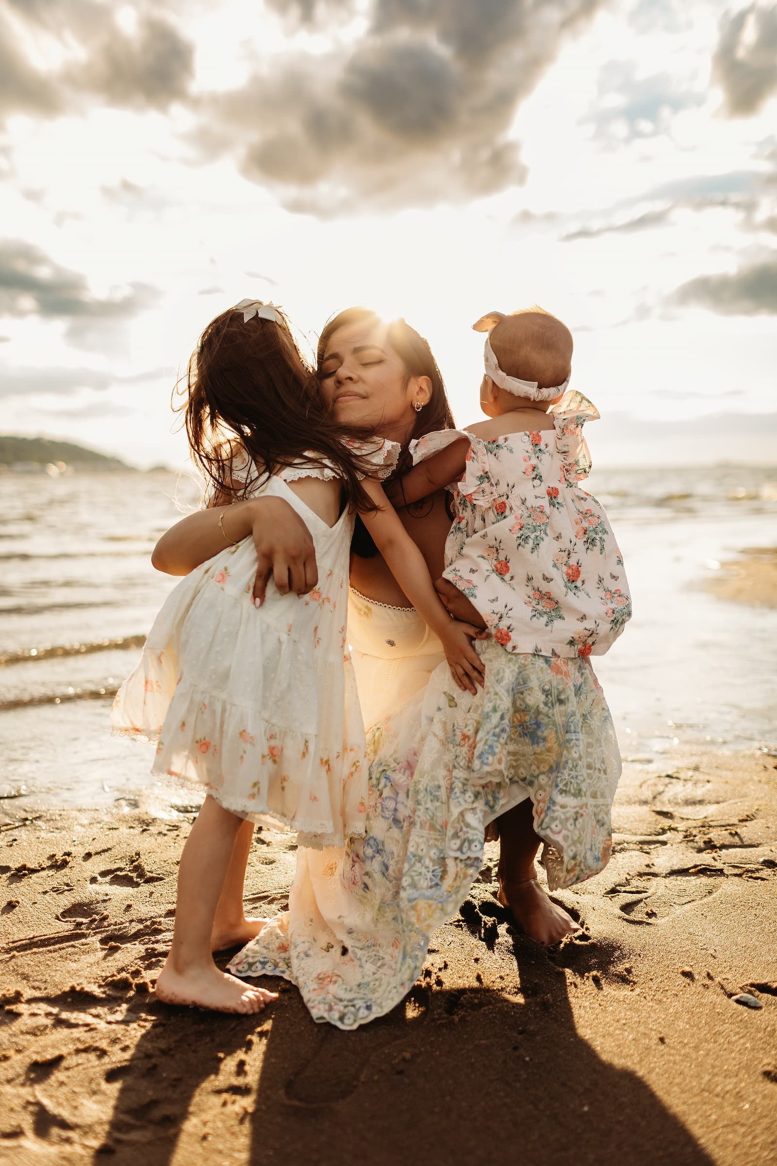 Alt text:
Mother embracing her two daughters during a sunset family photography session in New Jersey.