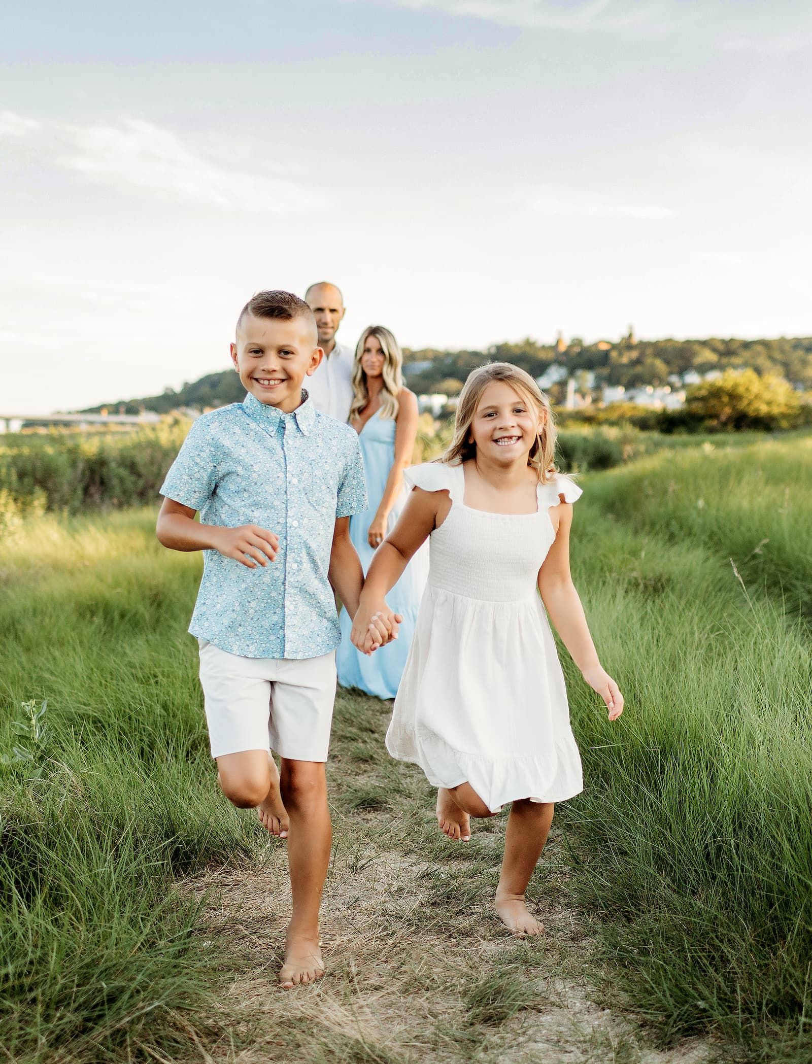 Brother and sister holding hands and running during an outdoor family photography session in Bergen County, NJ.