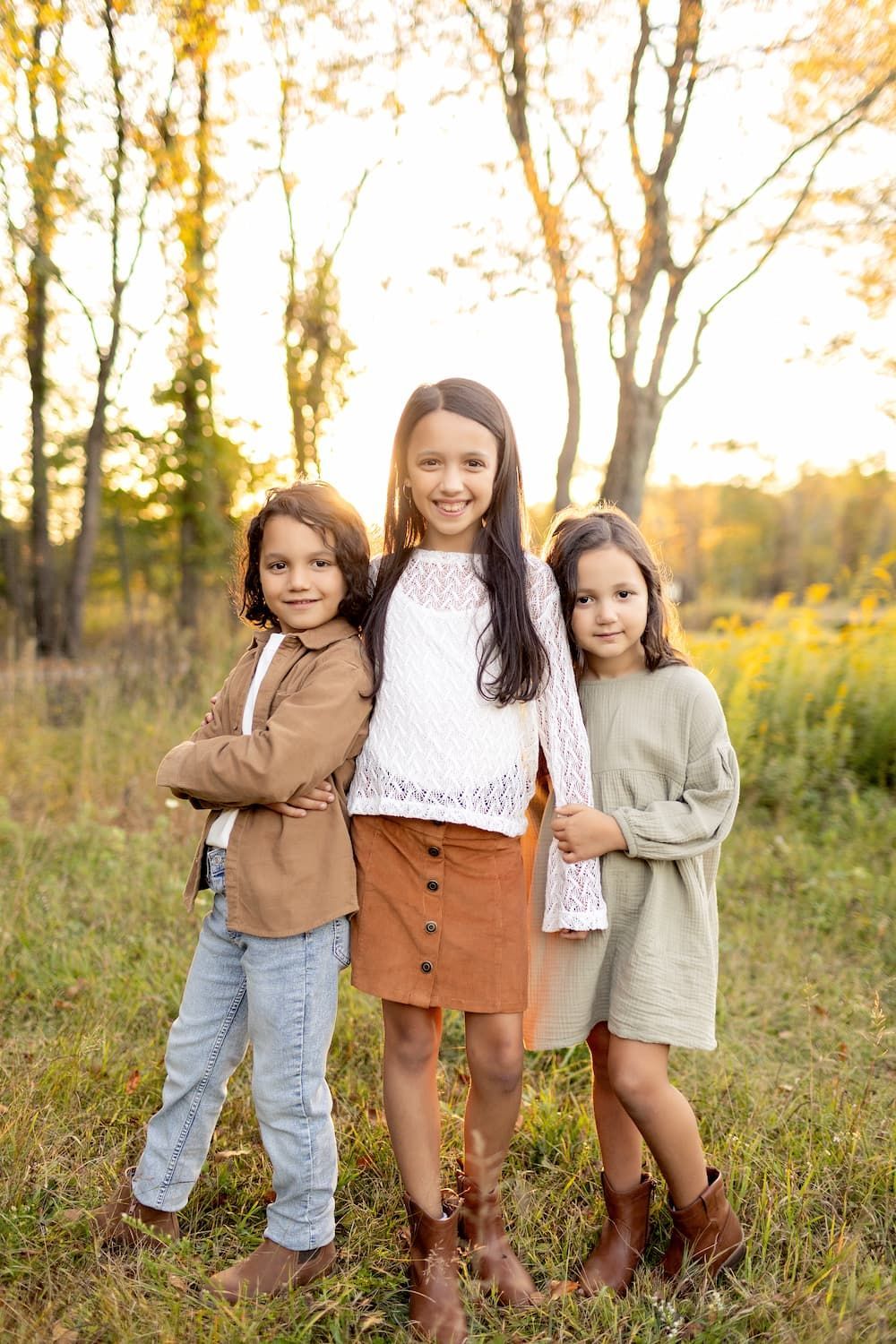 Three children together during a golden hour fall family photo session in Bergen County, NJ.