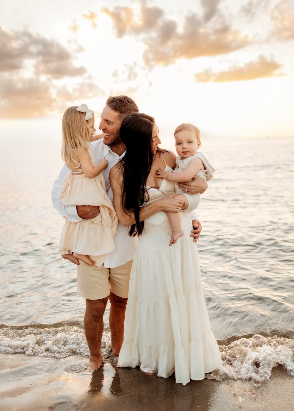 Mother embracing her two daughters during a sunset family photography session in New Jersey.