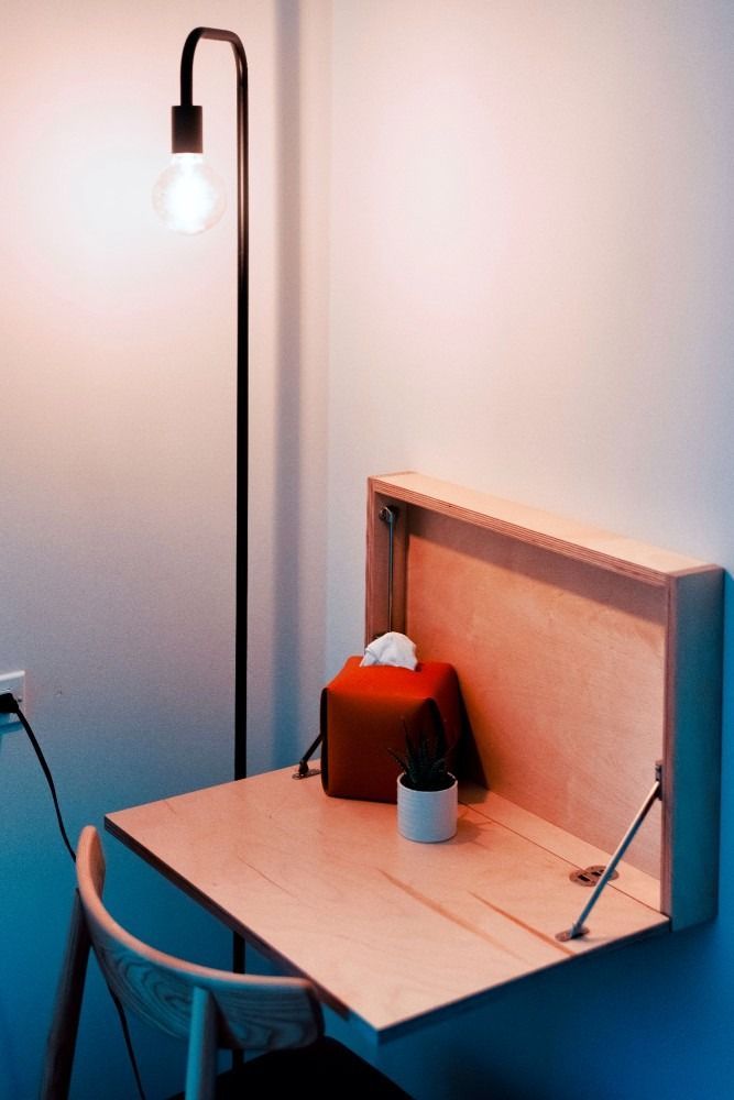 A small desk with a chair and a lamp on it