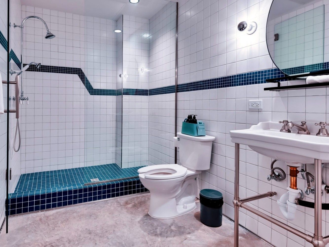 A bathroom with a toilet , sink , shower and mirror.