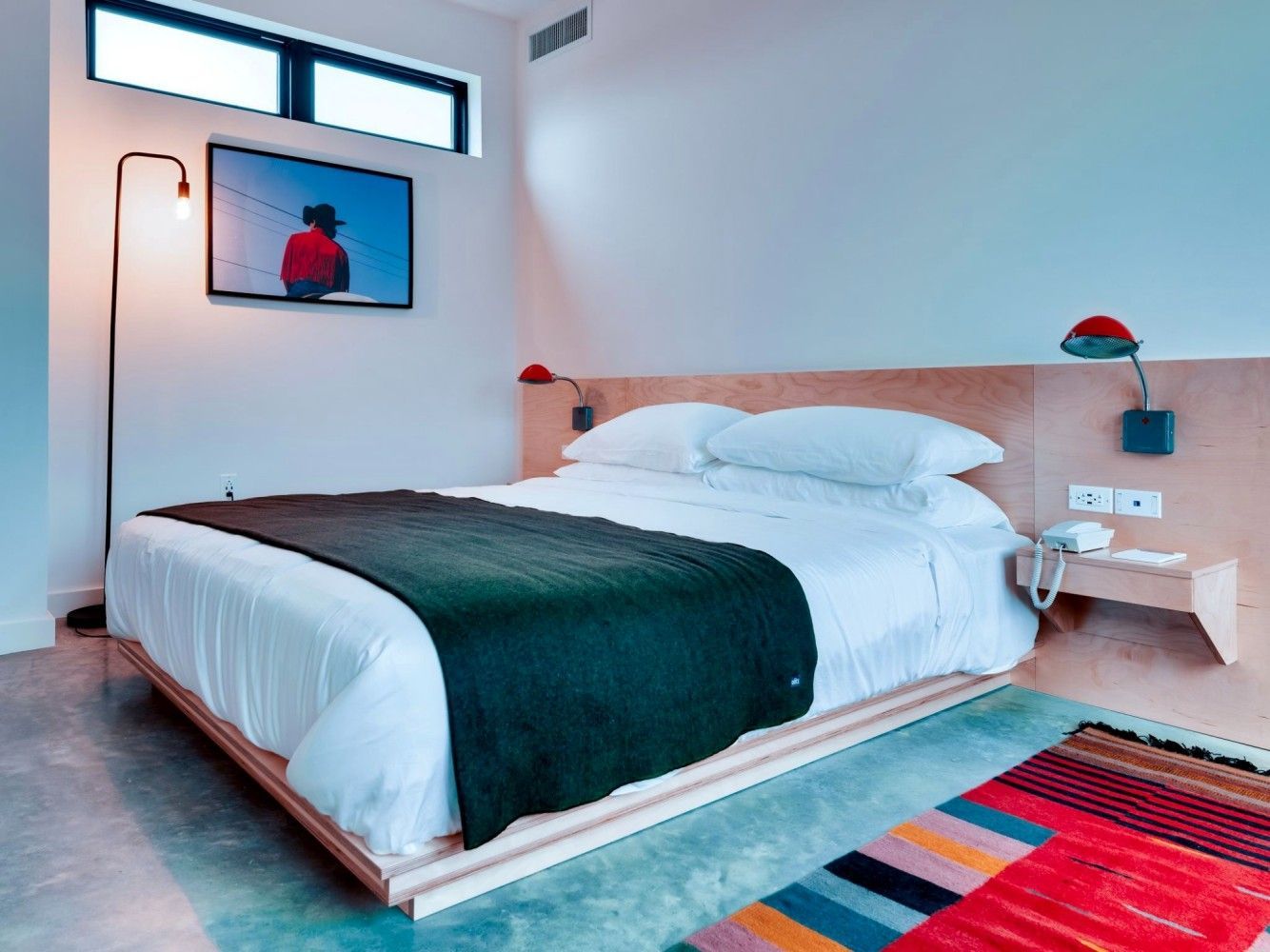 A hotel room with a large bed and a rug