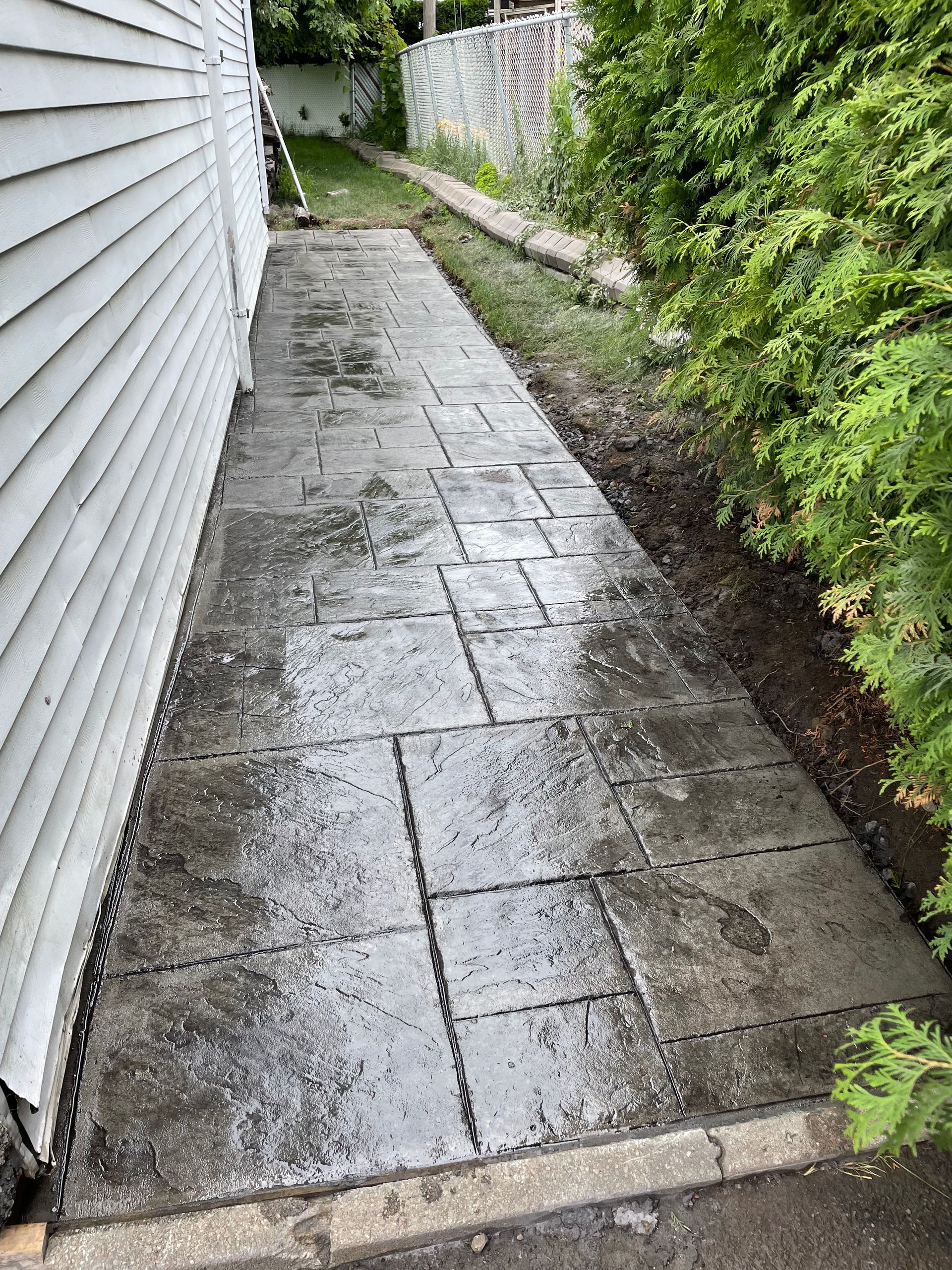 Un trottoir est en cours de construction à côté d'une maison.