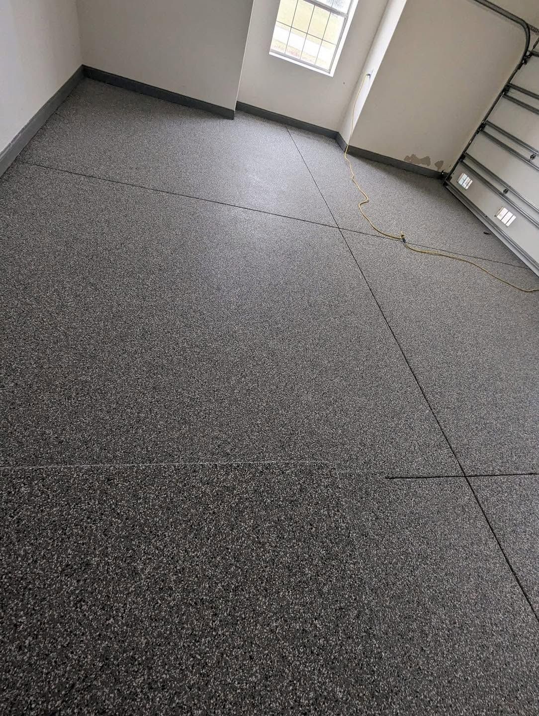 Empty room with gray carpet tiles, a small window, and built-in cabinets along the wall.