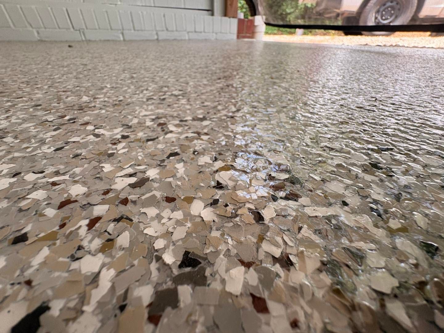 Speckled terrazzo floor with a low-angle view of a room and a car in the background