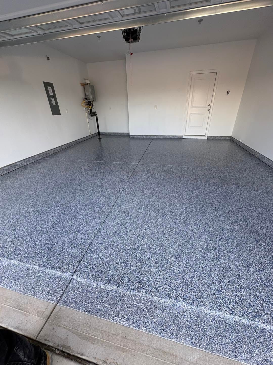 Empty residential garage with gray speckled epoxy floor and white walls